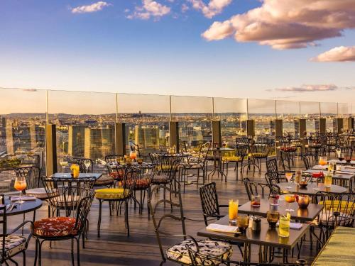 un ristorante con tavoli e sedie sul tetto di Too Hotel & Spa Paris - MGallery Collection a Parigi