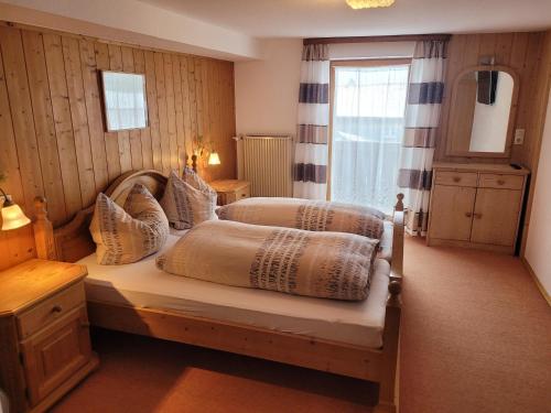 a bedroom with two beds and a window at Haus Steinacher in Hopferau