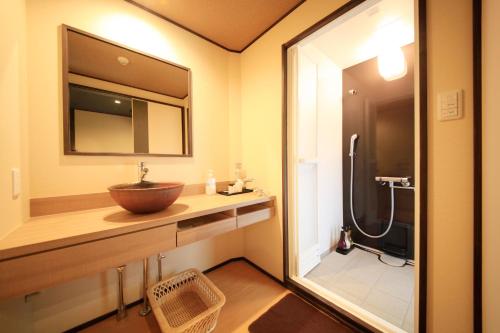 a bathroom with a sink and a large mirror at Hakone Suimeisou in Hakone