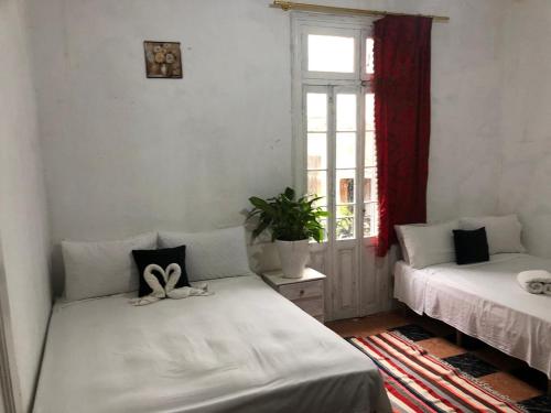 a room with two beds and a window at Pension Gibraltar in Tangier
