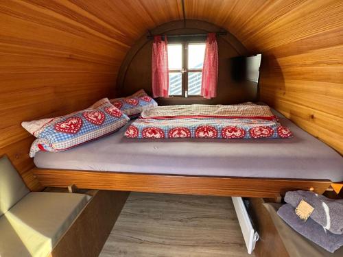 a bed in a small room with a window at Schlafen im Weinfass in Ipsheim
