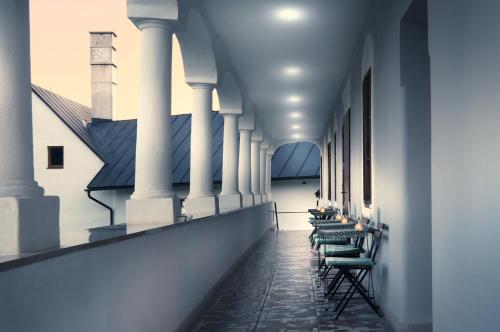 a row of chairs in a hallway with columns at Kaštieľ Čičmany in Čičmany