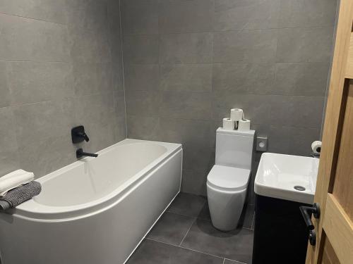 a bathroom with a tub and a toilet and a sink at Spring Meadow in Durham