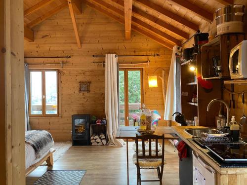 een keuken met een tafel in een houten huisje bij Chalet la Cabane d'Ernestine, petit-déjeuner inclus in Les Villards-sur-Thônes