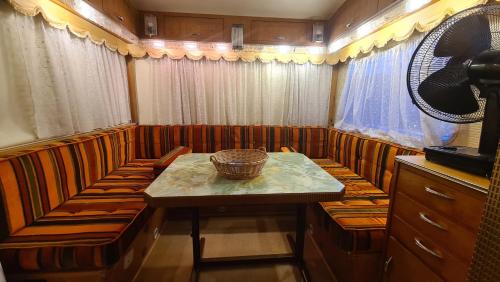 een eetkamer met een tafel en een mand erop bij Erlebe unseren Verein im geräumigen Wohnwagen! in Feldkirchen bei Graz