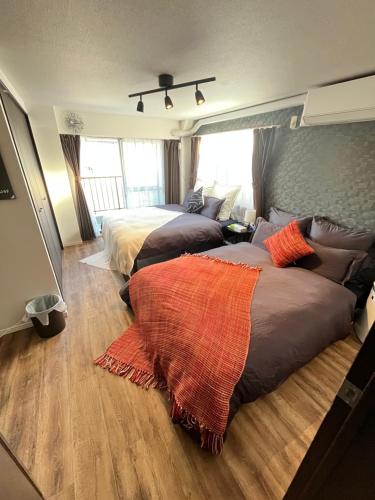 two beds in a bedroom with wood floors at Shimokitazawa Cozy Apartment 401 in Tokyo