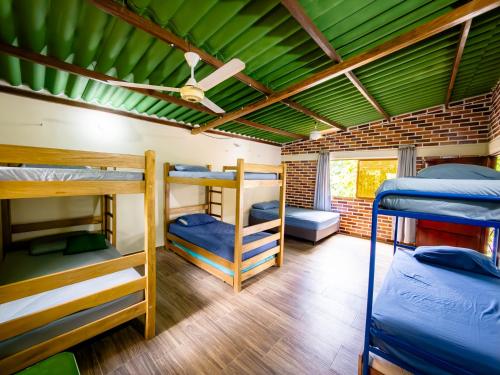 une chambre avec trois lits superposés et un plafond vert dans l'établissement Cabaña Casa Lila, à Santa Marta