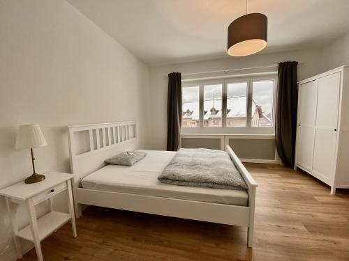 een slaapkamer met een wit bed en een raam bij Furnished Living Room in Günsberg Solothurn in Günsberg  