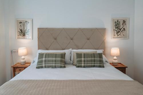 une chambre avec un lit blanc et deux lampes dans l'établissement Alojamientos Estrella Baeza, à Baeza