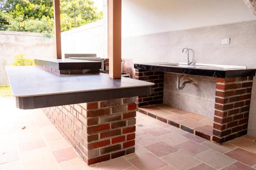 - une cuisine avec un évier et un mur en briques dans l'établissement Cabaña Casa Lila, à Santa Marta