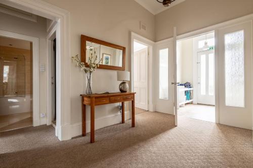 a room with a table with a vase of flowers on it at St Albans Lower - Elie in Earlsferry