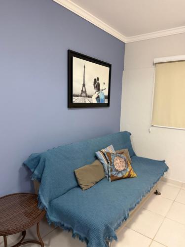 een blauwe bank in een kamer met de Eiffeltoren bij Mariscal 2 quartos 3 banheiros -SOBRADO AMENDOEIRA in Bombinhas