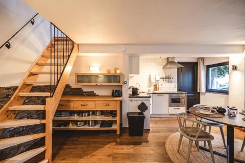 een keuken en eetkamer met een trap en een tafel bij Twin Pines in Durbuy