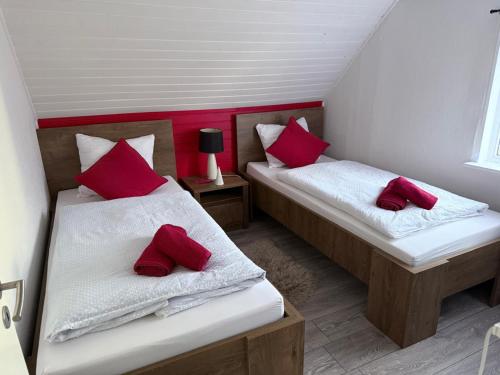 two beds in a room with red pillows at Stanza in zona turistica in Hirtshals