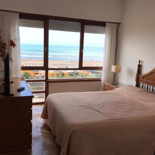 a bedroom with a bed and a view of the ocean at Amanecer del Mar in Necochea