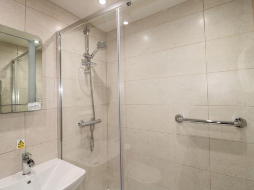 a bathroom with a shower and a sink at Primrose Cottage in Chathill