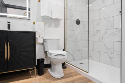 a bathroom with a toilet and a glass shower at Golden Hour @TheMillRowsSuites in New Glasgow