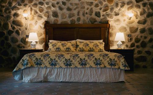 een slaapkamer met een bed met kussens en 2 lampen bij Hotel Boutique El Rosario in Teapa