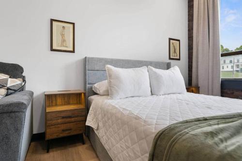 a bedroom with a bed and a couch at The Classic @TheMillRowsSuites in New Glasgow