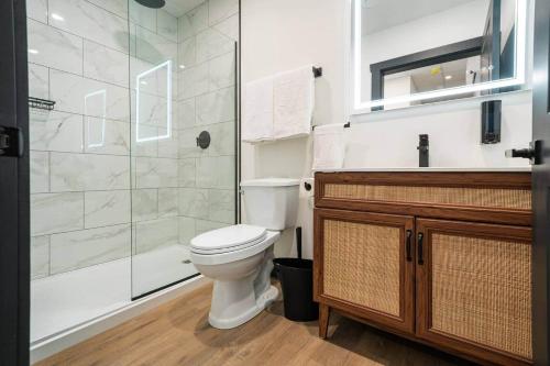 a bathroom with a toilet and a glass shower at The Classic @TheMillRowsSuites in New Glasgow