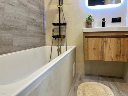 a bathroom with a bath tub and a sink at Central Park Apart Irpin in Irpin