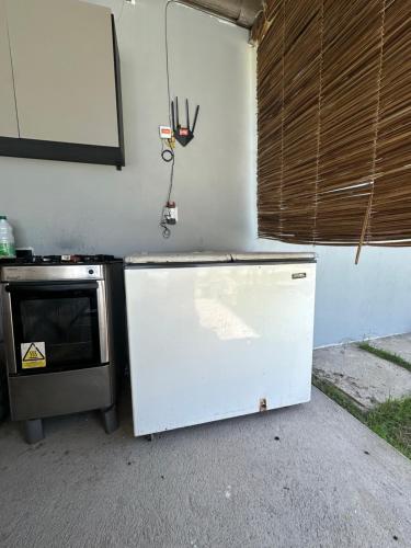 a kitchen with a stove and a white refrigerator at Espaço massagueira in Marechal Deodoro