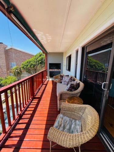 a balcony with wicker chairs and a couch at 360onSea in De Kelders