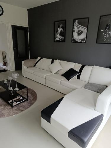 a living room with a white couch and a table at Lonzee in Gembloux