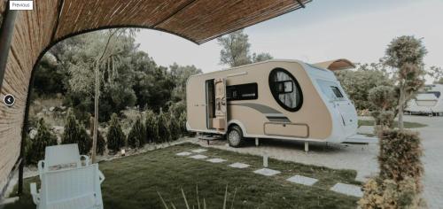 a white caravan parked in a parking lot at Güneş' te Karavan Otel in Karaburun