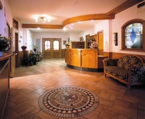 sala de estar con sofá y suelo de baldosa en Hotel Posta, en Forni di Sopra
