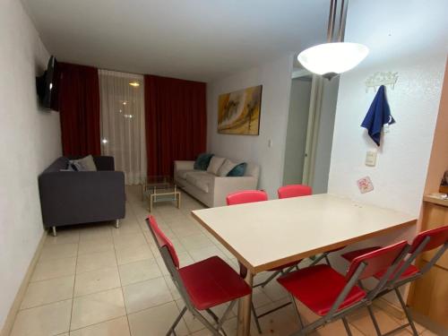 een woonkamer met een tafel en rode stoelen bij Apartment with a private backyard in Los Molles