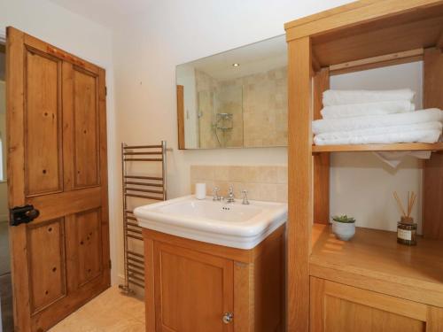 a bathroom with a sink and a mirror and towels at Tram Lane Cottage in Carnforth