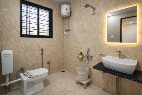 a bathroom with a sink and a toilet and a mirror at Hotel Sudarshan By Nath Bliss - Near Shrinathji Temple Just 2 Mins Walk in Nāthdwāra