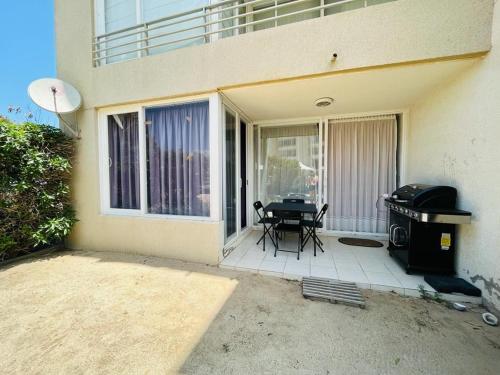 een patio met een grill voor een gebouw bij Apartment with a private backyard in Los Molles