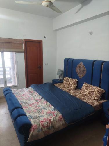a bed in a room with a blue couch at SerenityINn in Islamabad