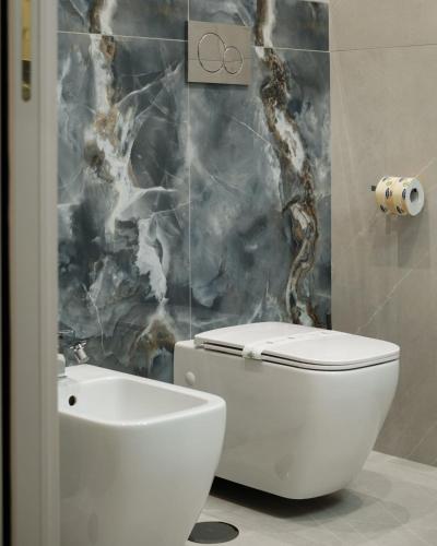 a bathroom with a white toilet and a sink at Ladi House in Nola