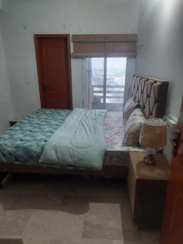 a bedroom with a large bed with a window at SerenityINn in Islamabad