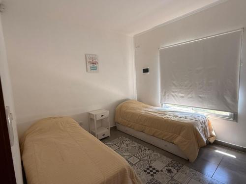 ein Schlafzimmer mit zwei Betten und einem Fenster in der Unterkunft La casita de Isa in Gualeguay