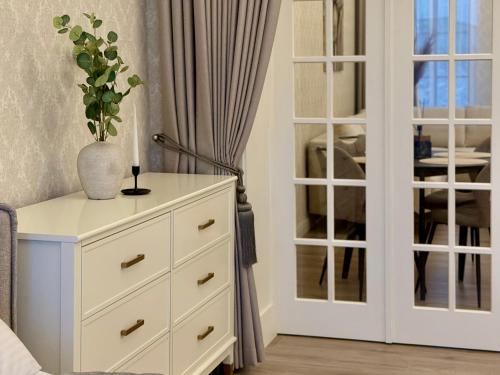 a white dresser with a vase on top of it at Insula Poilsio Namai in Telšiai