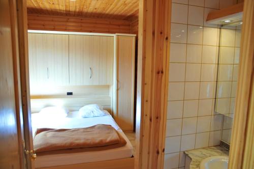 a small bedroom with a bed and a shower at Les Rochettes Pluton 3 in La Roche-en-Ardenne