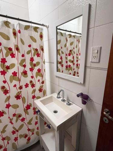 a bathroom with a sink and a shower curtain at La casita de Isa in Gualeguay