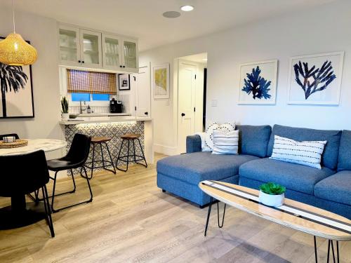 een woonkamer met een blauwe bank en een tafel bij Steps to Beach - New Surf Casita - AC & Cozy Fire Pit in Newport Beach