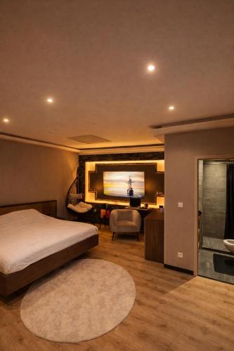 een slaapkamer met een bed en een flatscreen-tv bij Tomorrowland Luxury Apartment in Boom