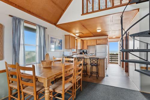 a kitchen and dining room with a wooden table and chairs at 4060 - Foxhole in Kitty Hawk Beach