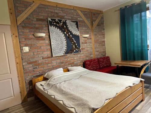 a bedroom with a bed and a brick wall at Pod Kasztanem in Wisła