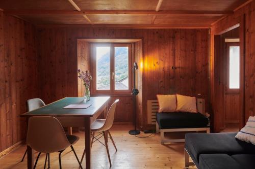 a living room with a table and a couch at Waterfall House - Art and Design, Ski, Hike, Swim in Mesocco