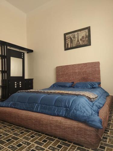 a bed with a blue comforter in a bedroom at Hospedaje en habitación casa colonial centro histórico Puebla in Puebla
