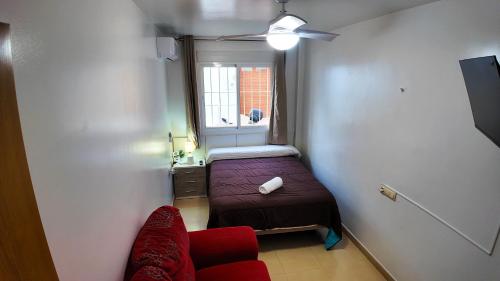 ein kleines Zimmer mit einem Bett und einem Fenster in der Unterkunft Apartalux Clara Campoamor in Carboneras