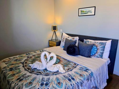 Twee witte zwanen zitten op een bed. bij White Design Apartment in Aveiro