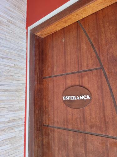 een houten deur met een bord erop bij Pousada Jeito Bom de Viver in Caraíva